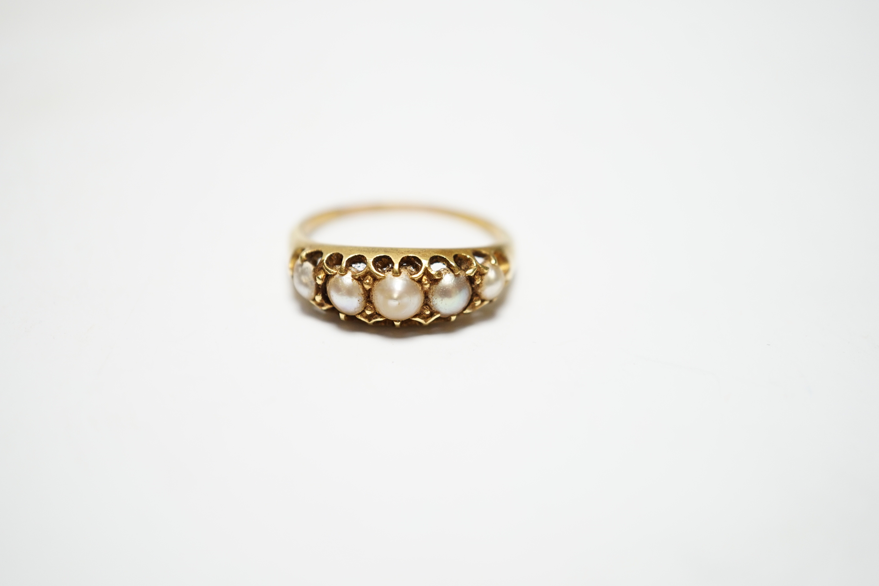A Victorian yellow metal and graduated split pearl set half hoop ring, size S, gross weight 4 grams.